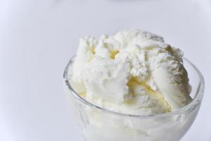 gelato dolce cremoso in una gelatiera di vetro su sfondo bianco foto