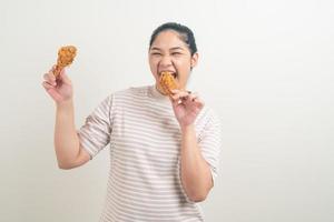 donna asiatica con pollo fritto a portata di mano foto
