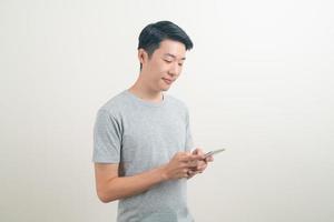 giovane uomo asiatico che usa o parla smartphone e telefono cellulare foto