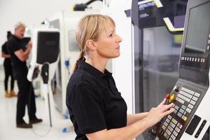 ingegnere femminile che gestisce macchinari cnc sul pavimento della fabbrica
