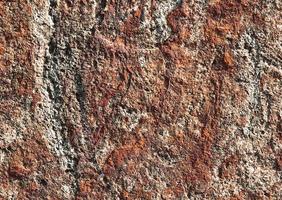 superficie della parete di roccia marrone rosso scuro, struttura astratta del fondo. foto