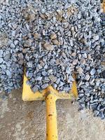 pala posta su un mucchio di pietra per lavori di costruzione. è usato per raccogliere la sabbia foto