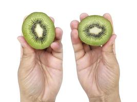 la mano tiene la metà affettata del kiwi isolata su fondo bianco foto