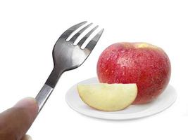 frutta mela su piatto e forchetta isolati su sfondo bianco foto