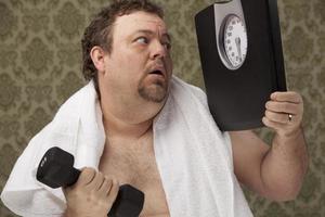 bilance per il sovrappeso maschile che lavorano duramente per perdere peso foto
