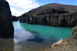 paesaggio islandese con un fiume che scorre attraverso grandi rocce foto
