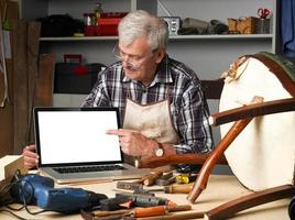 carpentiere in pensione con laptop foto