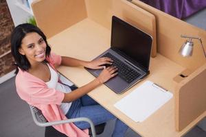 donna sorridente che scrive sul suo computer foto