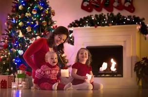 madre e bambini carini a casa alla vigilia di Natale foto