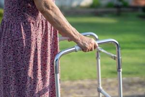 la donna anziana o anziana asiatica usa il camminatore con una buona salute mentre cammina al parco in una felice vacanza fresca. foto