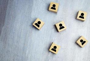 blocchi di cubo di legno con simbolo umano blu stampato. concetto di leadership e team building foto