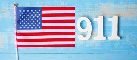 911 testo e bandiera degli stati uniti d'america sul fondo della tavola di legno. giorno del patriota, settembre, memoriale e concetto di non dimenticare mai foto