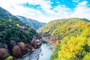 foglie colorate montagne e fiume katsura ad arashiyama, punto di riferimento del paesaggio e popolare per le attrazioni turistiche a kyoto, in giappone. autunno autunno stagione, vacanze, vacanze e concetto di visite turistiche foto