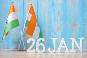 testo in legno del 26 gennaio con bandiere dell'india in miniatura. festa della repubblica indiana e concetti di celebrazione felice foto