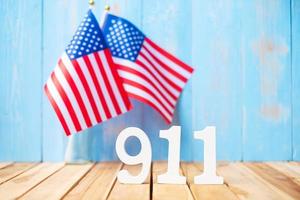 911 testo e bandiera degli stati uniti d'america sul fondo della tavola di legno. giorno del patriota, settembre, memoriale e concetto di non dimenticare mai foto