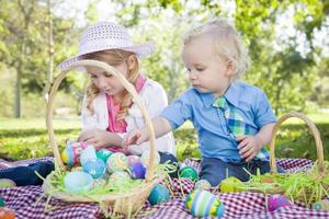 carino giovane fratello e sorella godendo le loro uova di Pasqua fuori