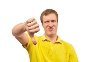 uomo infelice infastidito in maglietta gialla che mostra il gesto del pollice in giù isolato su sfondo bianco foto