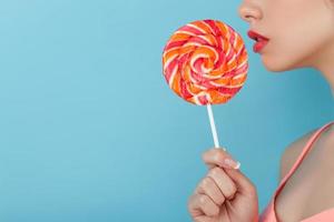 la giovane donna attraente sta godendo delle caramelle dolci foto