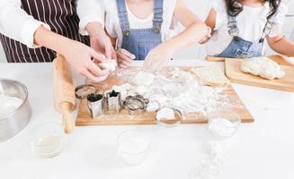 primo piano mamma e figlia aiutano a preparare l'impasto foto