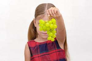 bambino che tiene grappolo d'uva foto