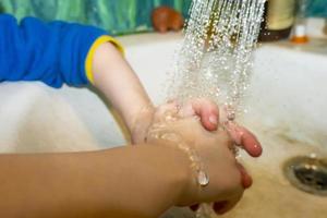 primo piano di uomo caucasico e bambino si lava le mani in bagno. covid - 19 prevenzione foto