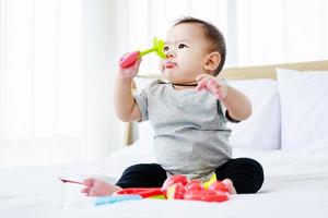 sviluppo nei bambini. bel bambino gioca con il giocattolo del bambino sul letto. foto