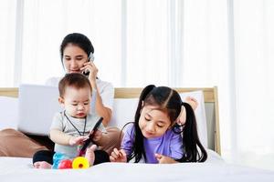 madre asiatica con bambina e bambina utilizzando lo stile di vita domestico del laptop foto