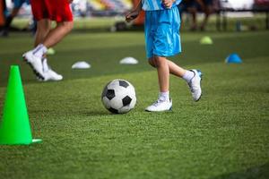 tattiche del pallone da calcio dei ragazzi sul campo in erba con il cono foto