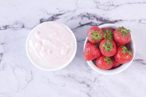 yogurt e fragola in una ciotola su bianco foto