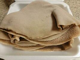 contenitore di schiuma con una pila di pane etiope chiamato injera foto