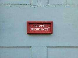 cartello rosso della residenza privata sulla porta di legno blu a casa foto