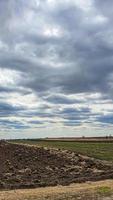 tempo di semina in ucraina durante la guerra. preparare i campi per la semina del grano. cielo azzurro, terra arata. terrore. foto