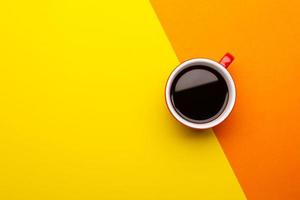 vista dall'alto caffè nero o americano in tazza rossa isolata su giallo foto