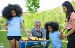 attività di vacanza in famiglia con nonno, madre e bambini con campeggio. barbecue grill e giocare in cortile insieme felicemente in vacanza. foto