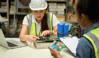 due magazziniere che contano oggetti in un capannone industriale al piano rialzato della fabbrica. che è un deposito per parti elettroniche piccole e leggere. foto