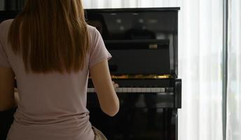 ragazza asiatica che suona il pianoforte in una mattina di sole. foto