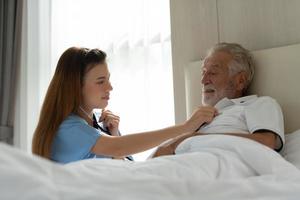 i medici si tengono per mano e incoraggiano i pazienti anziani che sono soli nella stanza speciale dell'ospedale. foto