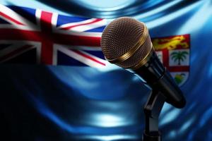 microfono sullo sfondo della bandiera nazionale delle Figi, illustrazione 3d realistica. premio musicale, karaoke, radio e apparecchiature audio per studi di registrazione foto