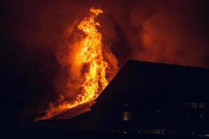 cottage caldo da un bar su sfondo nero. fiamma rossa naturale. Fuoco notturno foto