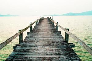 una passerella di legno che si protende nel mare. concetto di viaggio di vacanza foto