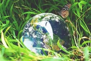 la sfera di cristallo con il mondo sull'erba. concetto di mondo e natura foto