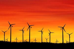 le turbine eoliche producono elettricità la sera. tramonto, silhouette, mulini a vento, energia pulita la sera. alternativa di concetto rinnovabile ed energia pulita ed eolica foto