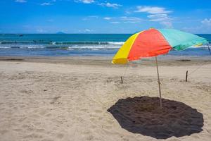 ombrellone colorato sulla spiaggia di sabbia sotto il cielo blu. viaggio per le vacanze estive. viaggio di vacanza tropicale. foto gratis