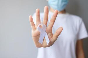 donna con nastro bianco per novembre mese di sensibilizzazione sul cancro ai polmoni, democrazia e giornata internazionale della pace. concetto di assistenza sanitaria foto