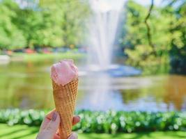 gelato all'arancia su fiori primaverili o estivi sullo sfondo del paesaggio. cibo, viaggi, concetto di stile di vita foto