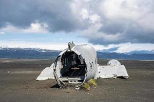 rottame aereo rotto sulla spiaggia di sabbia nera di solheimasandur contro il cielo nuvoloso foto