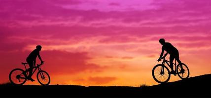 sagoma di un mountain biker godendo in discesa durante il tramonto. concetto di mountain bike. gara di mountain bike - ciclista silhouette sullo sfondo. foto