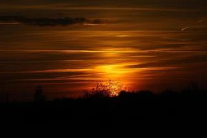 sole che tramonta alla periferia di berlino. il cielo sembra bruciare foto