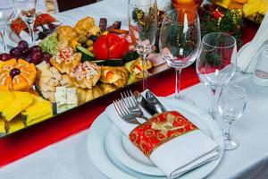 bella tavola festiva servita per la cena di celebrazione del matrimonio a casa o all'interno del ristorante. tavola piena di cibo in un ristorante. tavola rotonda completa. foto