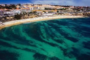 Vista aerea del drone della spiaggia di sao pedro do estoril a sao pedro do estoril, grande lisbona, portogallo sullo sfondo foto